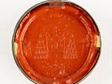 a small tin with a red paint on it