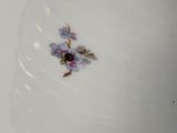a white plate with a flower on it sitting on a table