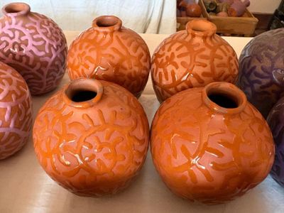 cinq vases de couleurs différentes posés sur une table