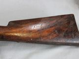 an old wooden rifle is laying on a white cloth