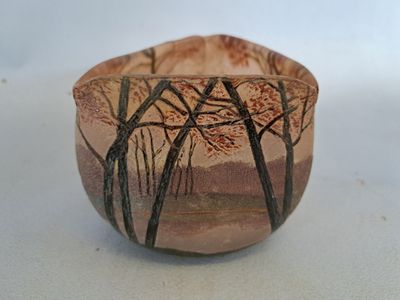 a small bowl that has a picture of trees on it