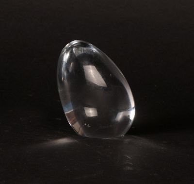 a clear glass object sitting on a black surface