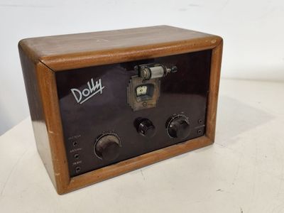 une vieille radio posée sur une table en bois près d'un mur blanc