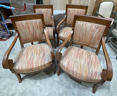 quatre chaises en bois avec des assises rembourrées à rayures dans une pièce