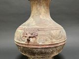 a large vase with a lion head on it