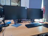 a desk with two monitors and a keyboard on it