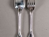 two spoons and a fork sitting on a table
