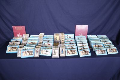 many books on a table with a blue table cloth