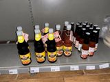 many bottles of sauce on a shelf in a store