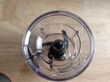 a blender on a wooden table with a box of food in the background