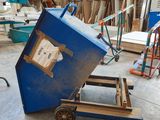 a blue cart with a box on it in a warehouse