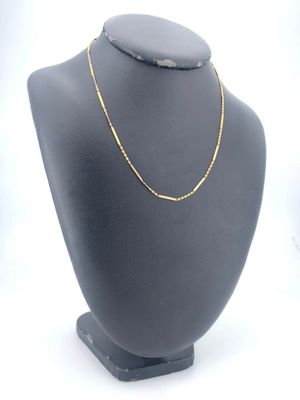 a close up of a necklace on a mannequin with a white background