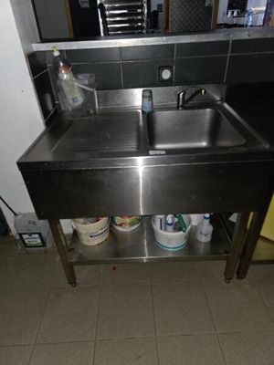 a stainless steel sink and a metal counter in a kitchen