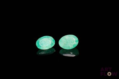 une paire de boucles d'oreilles vertes phosphorescentes sur fond noir