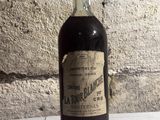 a bottle of liquor sitting on a table next to a brick wall