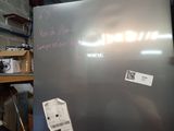 a silver refrigerator with a lot of stickers on it