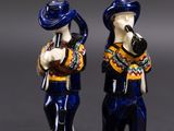 deux figurines représentant un homme et une femme portant un chapeau