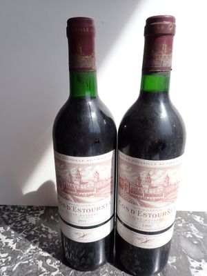 two bottles of red wine sitting on a table
