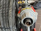 a machine that is sitting on the floor next to a bunch of hoses