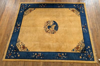 un tapis jaune bordé de bleu posé sur un parquet
