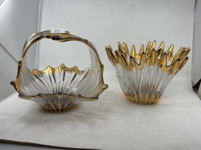 une paire de vases en or et en verre transparent posés sur une surface blanche
