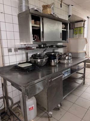 une grande cuisine avec de nombreux plans de travail en inox