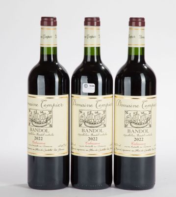 trois bouteilles de vin sont alignées sur une surface blanche