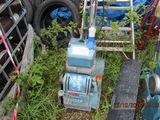 a small blue machine that is sitting in the grass