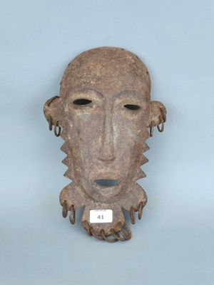 un gros plan d'un masque accroché au mur, sur lequel figure un tag