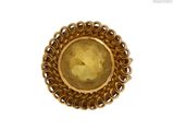 une image représentant une bague en or avec une pierre jaune au centre