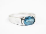 Gros plan sur une bague contenant une pierre bleue