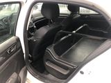 a white car with its door open and a black seat in the back
