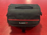 un sac photo noir posé sur une table rouge