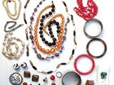 many different types of necklaces and bracelets laid out on a table