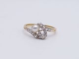 une bague en perle blanche et diamants posée sur une surface blanche
