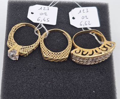 three pairs of gold rings with diamonds on a black cloth
