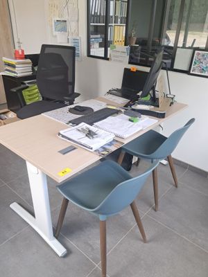 un bureau avec deux chaises et un ordinateur dessus