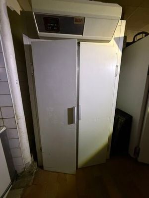 un réfrigérateur blanc dans le coin d'une pièce