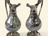 deux vases en argent posés l'un à côté de l'autre sur une table