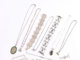 various necklaces and bracelets are arranged on a white surface