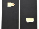 two pieces of black cardboard with a piece of paper sticking out of it