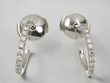une paire de boucles d'oreilles créoles en diamant sur fond blanc