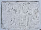 une image représentant un relief en pierre représentant un homme, une femme et un enfant