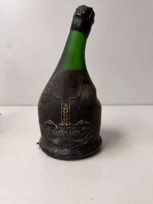 a bottle of wine sitting on a table next to a bottle of wine