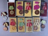 many medals and medals in small boxes on the table