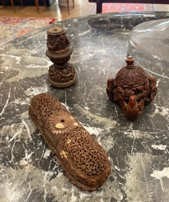 trois objets en bois sculpté sont posés sur une table dans un salon