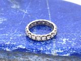 un gros plan d'une bague posée sur un rocher, sur fond bleu