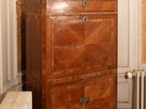 a dresser in the corner of a room with a radiator in the corner