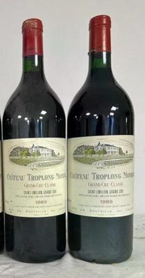 three bottles of red wine are lined up on a table