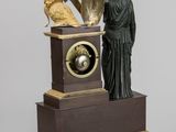 a statue of a man holding a clock with a bird on top of it
